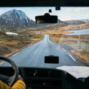 Focus on view from inside adventure car or camper van on amazing cinematic scandinavian landscape. Travel on epic road trip through mountains. Nomadic vanlife lifestyle. Life on the road